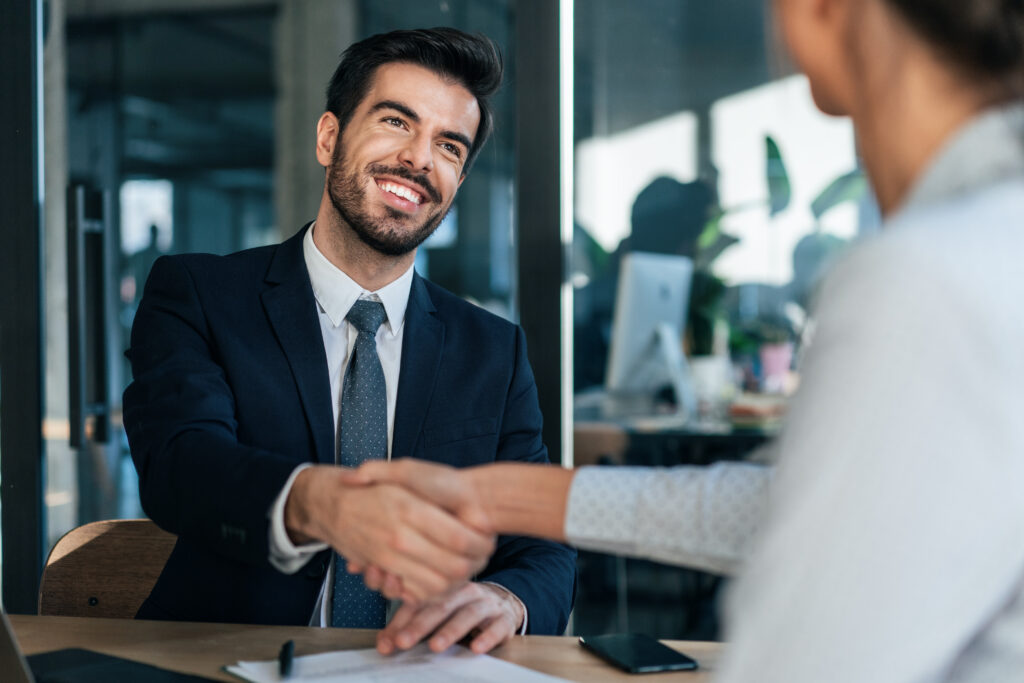 Happy Smiling young business persons shaking hands after signing a contract